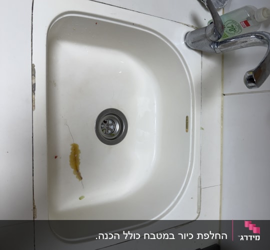 כיור מטבח סדוק המותקן במשטח שיש לפני תיקון